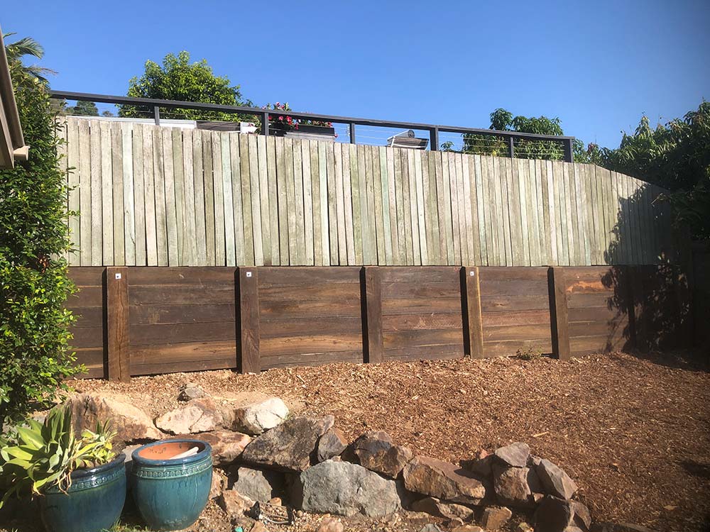 Hardwood sleeper retaining wall with a timber fence on the inside