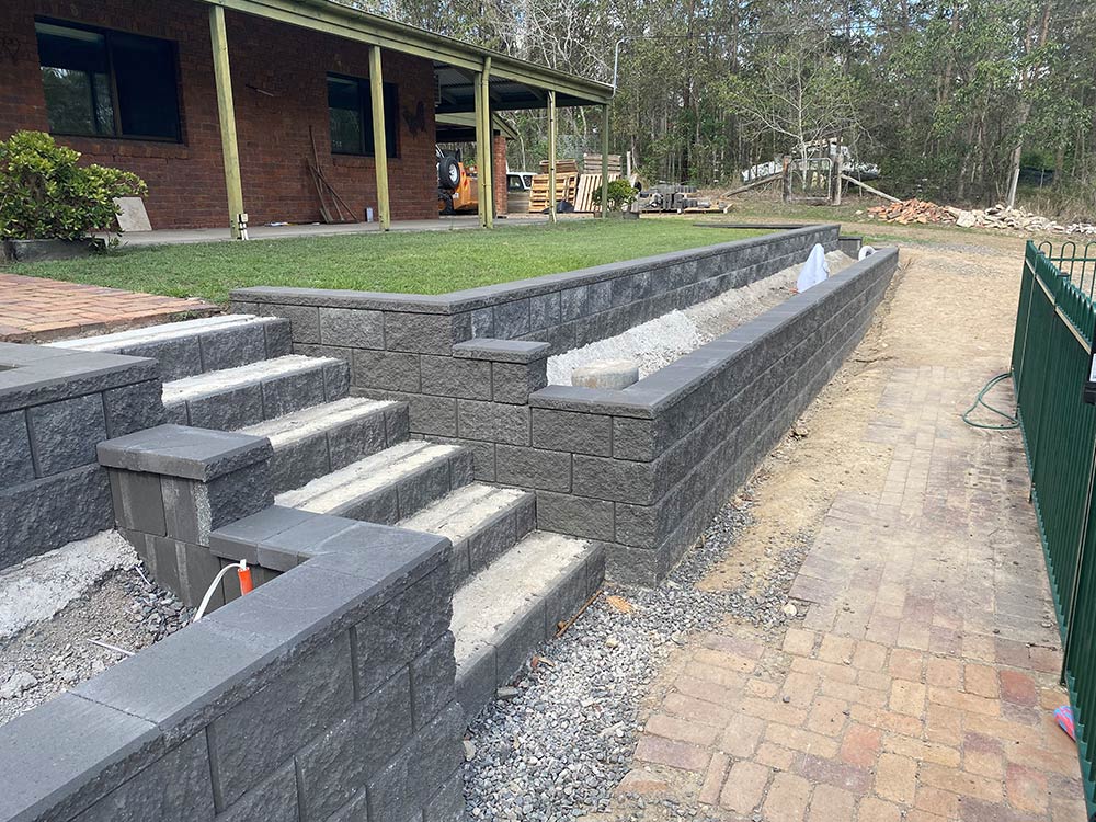 Terraced stack stone retaining wall wit steps